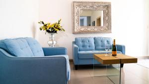 蓬塔卡纳Boutique Hotel Las Flores Punta Cana的客厅配有2把蓝色椅子和镜子