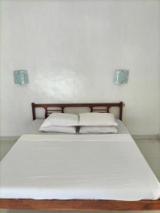罗威那娜湾海滨别墅酒店的一张带白色床单和枕头的床