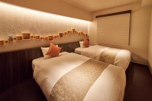 东京SAKE Bar Hotel Asakusa的酒店客房设有两张床和窗户。
