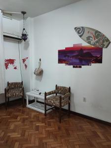 里约热内卢#Apartamento aconchegante no Flamengo - RIO的一间设有两把椅子的房间和墙上的一幅画