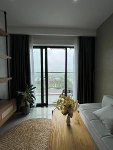 顺化Moon homestay, apartment Hue的客厅配有沙发和鲜花桌