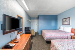康瑟尔布拉夫斯Broadway Inn的酒店客房设有两张床和一台平面电视。