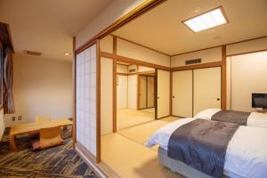 富士河口湖Motosu Phoenix Hotel的卧室设有大窗户和一张床