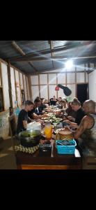 Ban NongbouaShared Happy Farm的一群人坐在餐桌旁吃着食物