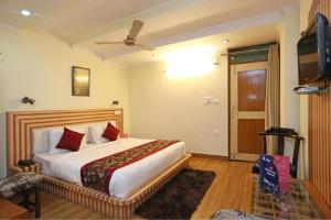 奈尼塔尔Goroomgo Moon Nainital Near Naini Lake - Parking & Lift Facilities -Hygiene and Spacious Room - Best Seller的一间卧室配有一张大床和电视