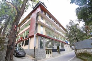 奈尼塔尔Goroomgo Moon Nainital Near Naini Lake - Parking & Lift Facilities -Hygiene and Spacious Room - Best Seller的前面有停车位的建筑