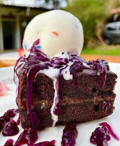 蒙特内哥罗Hotel Campestre Veredal - Quindío - Eje Cafetero的一块巧克力蛋糕,有白色和紫色的冰块