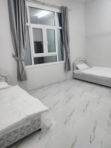 MisfāhJabal Shams, Al Noor house جبل شمس的一间铺有白色大理石地板的卧室和窗户