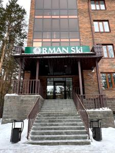 ShchuchinskiyOrman Ski的通往雪地中带楼梯的大楼的入口
