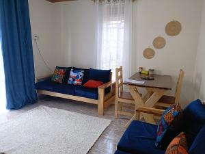 金贾Amaryllis blue,8mins source to River Nile,secure, peaceful, central great location的客厅配有蓝色的沙发和桌子