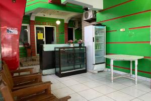 肯达利OYO 93770 Pondom Danu 77的绿色客房配有桌子和冰箱