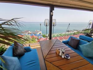 敖德萨Подвійний котедж з терасою біля моря Совіньон的一个带桌子和蓝色椅子的庭院和大海