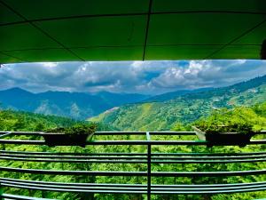 西姆拉Aachman Nature Valley Resort Shimla的阳台享有山景,种植了植物。
