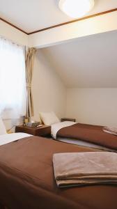 嬬恋村Murmure　6人家族や友人向け　ペット可的酒店客房设有两张床和窗户。