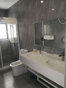 鲸湾港City Centre Hotel的浴室配有2个盥洗盆、卫生间和淋浴。