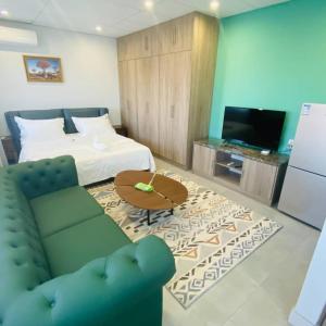 鲸湾港City Centre Hotel的客厅配有床、沙发和电视。