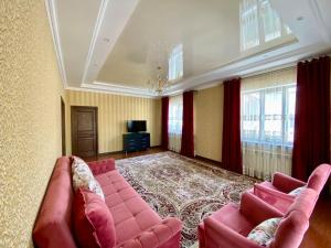 阿拉木图Askarov House的客厅配有粉红色的沙发和电视