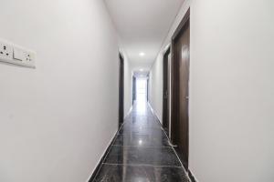 新德里FabExpress Super 8 Residency的走廊上设有白色的墙壁和黑色的门