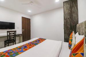新德里FabExpress Super 8 Residency的一间卧室配有一张床和一张桌子及椅子