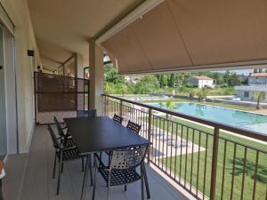 拉齐塞Residence La Magnolia - Aparments的一个带桌椅的阳台和一个游泳池