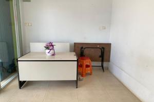名古屋SPOT ON 93776 Intan Homestay的一间设有白色书桌和盆栽的房间