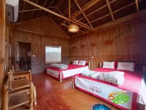 Trai ÐỏĐảo Chè Thanh Chương - Homestay Gió Lào的木房里设有三张床的房间