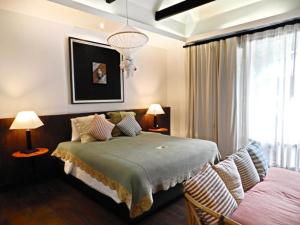 清迈Baan Saen Fang Chiang Mai - SHA Plus的一间卧室配有一张床、两盏灯和一个窗户。