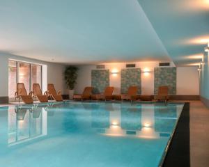 蒂门多弗施特兰德Appartement-Hotel Timmendorfer Strand的一座配有桌椅的酒店游泳池