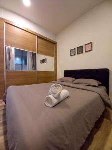 古晋Cozy Home at Near Centre and Airport @ Galacity的一间卧室配有一张床,床上有毛巾