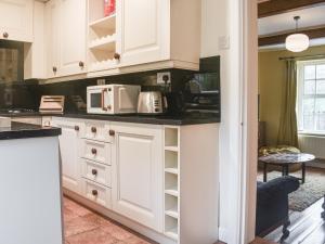 Luddenden FootVintage Cottage的厨房配有白色橱柜和白色家电