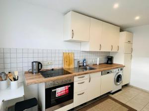霍登哈根Ferien/Monteurwohnung Hodenhagen的厨房配有白色橱柜、水槽和洗碗机。