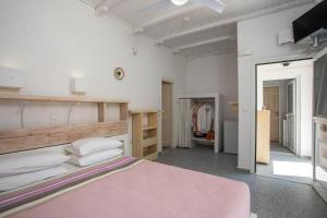 里瓦的亚Hotel Irini的卧室配有粉红色的床和衣柜。