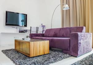 牛汝莪Three Storey Garden Home at Bukit Gambir 18ppl的客厅配有紫色沙发和茶几