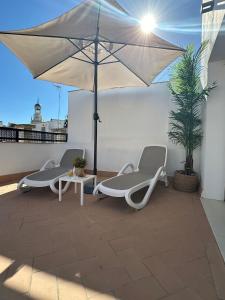 加的斯Soho Boutique Cádiz的屋顶上设有两把椅子、一张桌子和一把雨伞