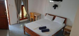 阿鲁甘湾Ocean Vibe Srilanka的一间卧室配有一张带两个枕头的床