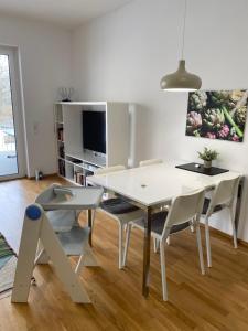 林茨Ebelsberger Terrassen的白色的用餐室配有白色的桌椅