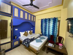 西姆拉BNB ROYAL INN SHIMLA的一间卧室配有一张蓝色墙壁的床