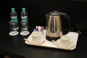 帕拉尼HOTEL SR的茶壶、桌子上的杯子和瓶装水