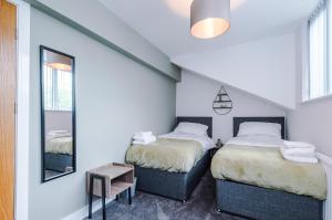 埃杰顿4 bed property, Bolton , Manchester的一间卧室配有两张床和镜子