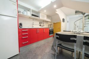 巴塞罗那Barcelona Apartment Near Park Güell的厨房配有红色橱柜和桌椅