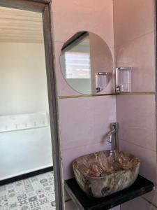 VajapūrILA Villa的一间带石制水槽和镜子的浴室