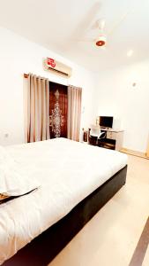拉瓦尔品第QueensLand villa near Islamabad airport & motorway的一张大白色的床,位于带书桌的房间里