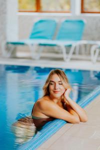 伯伊莱图什纳德Hotel O3zone的躺在游泳池中的女人