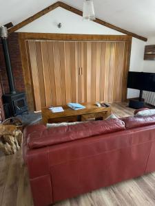 HorspathStable lodge 2 Bedrooms的客厅配有红色的沙发和木桌