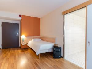 斯图加特斯图加特市中心宜必思酒店的一间卧室设有一张床和一个滑动玻璃门
