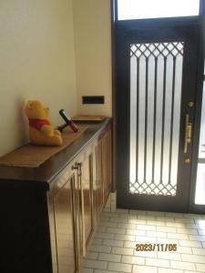 富山Private inn “Come! Akae House” - Vacation STAY 61227v的坐在门边的柜台上的泰迪熊