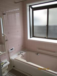 富山Private inn “Come! Akae House” - Vacation STAY 61227v的带浴缸、窗户和粉红色瓷砖的浴室