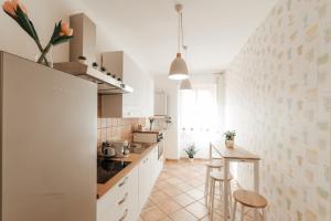 奇维塔韦基亚CR32 TOURIST ACCOMODATION的厨房配有白色橱柜和桌椅