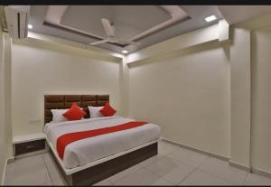 艾哈迈达巴德HOTEL SUNWAY的一间卧室配有一张带红色枕头的床和天花板
