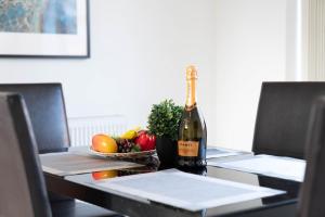 伯明翰Detached 3 Bedroom House - Gaerden - Parking - Top Rated - Netflix - Wifi - 98C的一瓶香槟和一碗水果放在桌子上